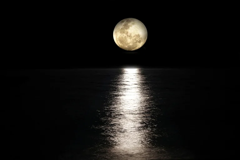 Full moon shining over the sea at night